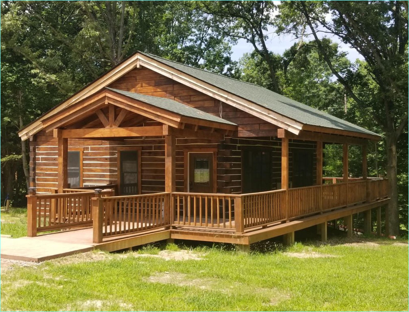 Log cabin kit exterior with wood siding surrounded by trees