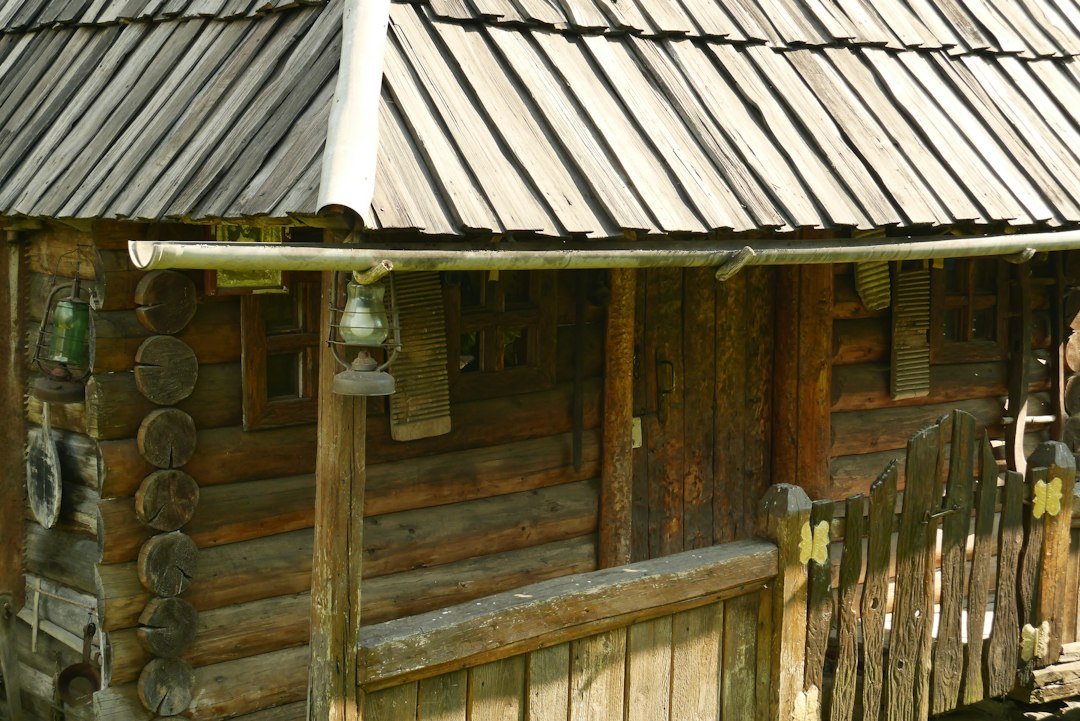Rustic log cabin with a wooden shingle roof and small front porch