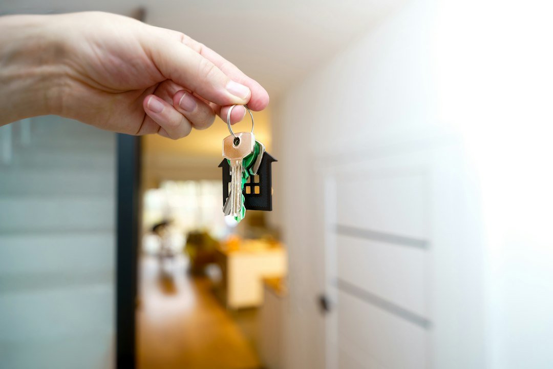 Hand holding house keys inside a new home after closing on a loan