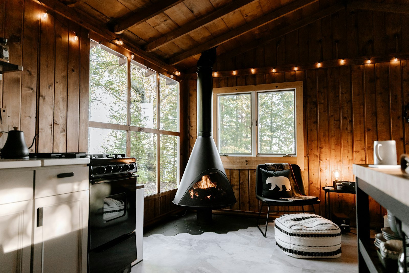 Wood-burning stove inside a cozy cabin room, the main heat source that determines how much firewood you need